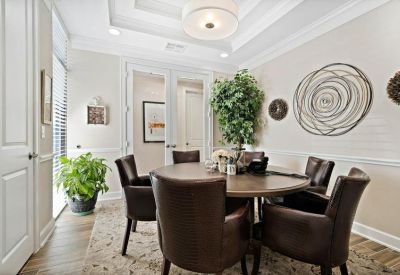 Private office featuring a round wooden table, leather chairs, and abstract wall art.