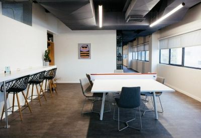 Meeting area with a white table, modern black chairs, and a minimalist wall art piece.