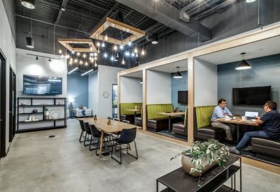 Communal break area featuring green booth seating and modern light fixtures.