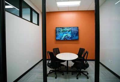 Spacious reception lounge with a yellow sofa and blue patterned rug.