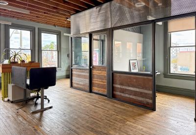 Spacious office interior at 130 East Congress Street with exposed wood ceilings and glass partition walls.