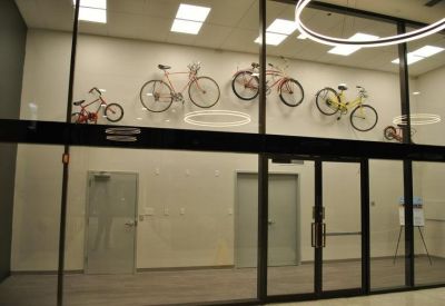 Office area featuring a glass wall decorated with several bicycles mounted for display.