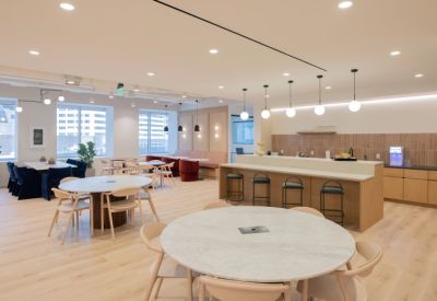 Spacious communal lounge and kitchen area with marble tables and modern pendant lighting.