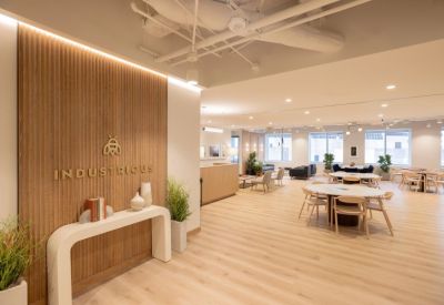 Reception area with a wood-slat feature wall and the Industrious logo.
