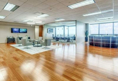 Spacious reception area with polished wood floors and a modern desk.