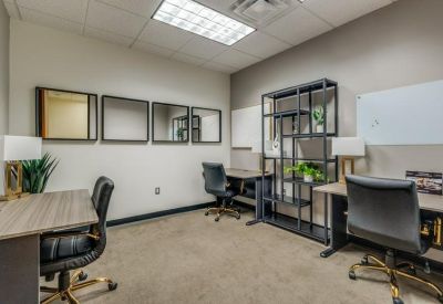 Three-person private office with wooden desks and wall mirrors.