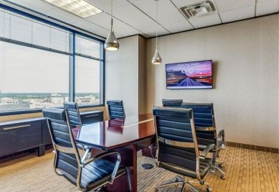 Boardroom with a long wooden table and blue leather chairs.