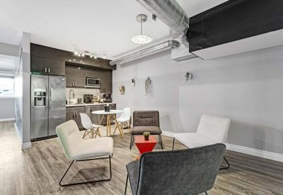 Communal break area with a kitchen, dining table, and lounge chairs.
