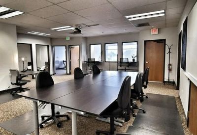 Large meeting room with a dark wood conference table and several black chairs.