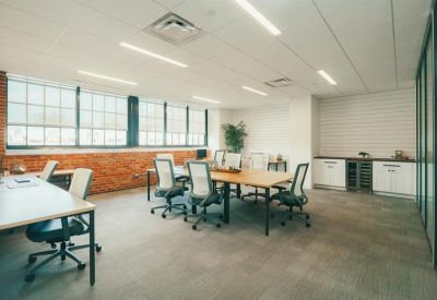 Bright common area with a long wooden table and modern seating options.