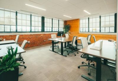 Bright coworking area with exposed brick walls and several workstations.