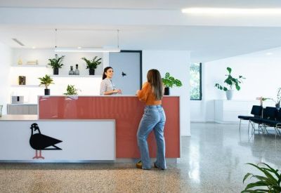 Modern reception desk with a pigeon logo and vibrant orange accents.