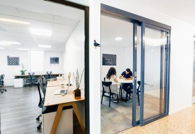 Private glass-walled office suites with ergonomic chairs and wooden desks.