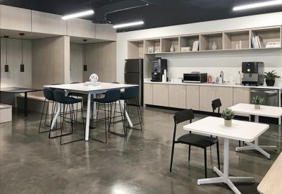 Communal kitchen area with tables and coffee machines.
