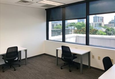 Private office with two desks and large window view.