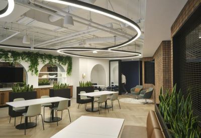 Modern dining area with curved linear lighting, white tables, and indoor greenery.