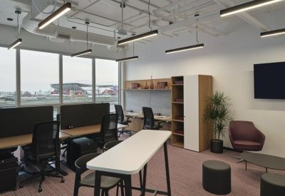 Bright open-plan workspace featuring height-adjustable desks and views of the city.