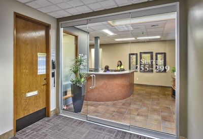 Welcoming reception desk visible through glass doors with tiled flooring.