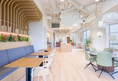 Spacious communal dining area with various seating arrangements and a sleek kitchenette.