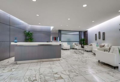 Modern reception area with a marble floor and comfortable white seating.