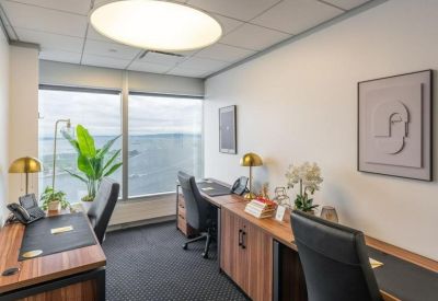 Two-person private office with wooden desks, brass lamps, and large windows.