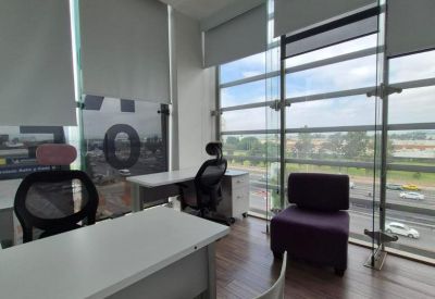 Bright private office suite with white desks, ergonomic chairs, and large windows overlooking the city.