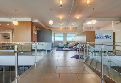 Spacious reception area with warm wood paneling and sleek glass railings.