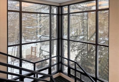 Modern stairwell landing featuring expansive windows and mountain views.