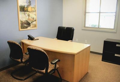 Private office with a light wood desk and blue wall.