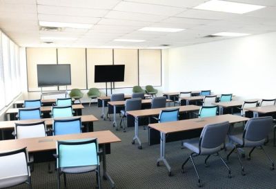 Large training room with rows of desks and blue chairs, 1903 Central Drive, Bedford, Texas.