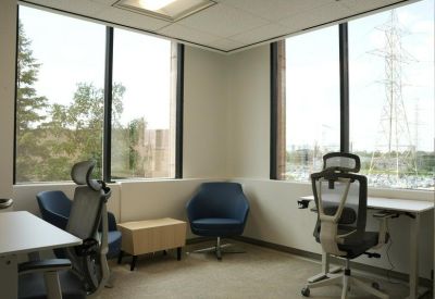 Sunlit private office suite with ergonomic chairs and large corner windows.