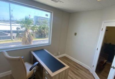Bright private office featuring a wooden desk and large window view.