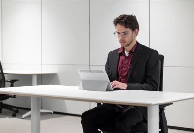 Individual workstation with a height-adjustable desk and ergonomic chair.