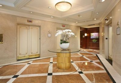 Elegant elevator lobby featuring polished marble floors with a geometric diamond pattern.