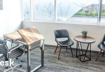 Bright workspace featuring a light wood desk and a small round side table by a window.