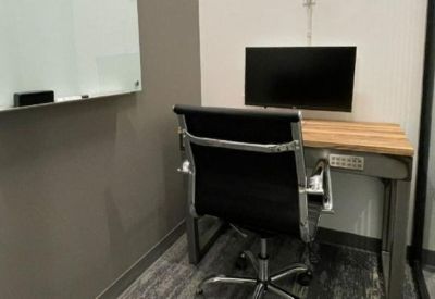 Private office space with a wooden desk, black chair, and a white whiteboard.