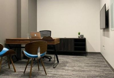 Individual workspace featuring a wooden desk and modern seating in a quiet office setting.
