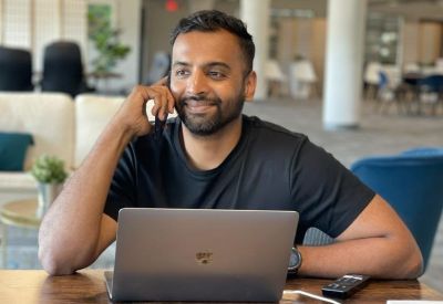 A person working at a laptop in a bright, modern coworking space at 201 North Main Street, 4th Floor.