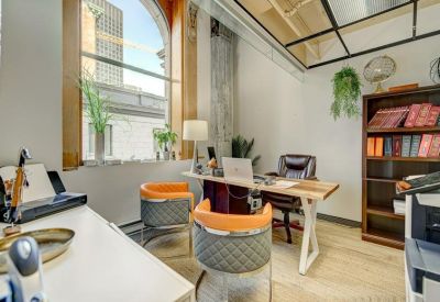 Private office featuring a wooden desk, arched window, and bookshelves.