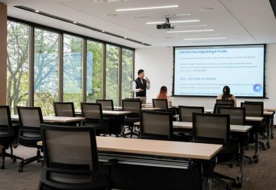 Training room set up with rows of desks facing a projector screen.