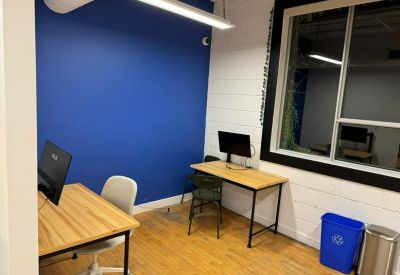 Private office suite featuring a blue accent wall, two desks, and hardwood floors.