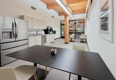 Modern communal kitchen and dining area featuring wooden ceilings and stainless steel appliances.