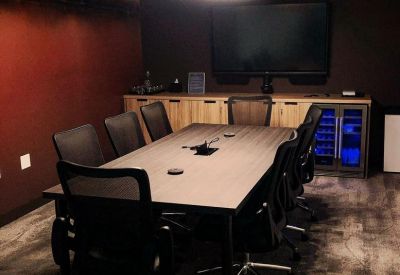 Professional conference room with a long wooden table, plush seating, and sound-dampening ceiling.