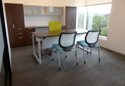 Professional private suite with a large desk, ergonomic chairs, and a large window.
