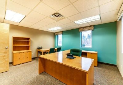 Private office suite with a large desk and teal accent wall.