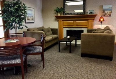 Inviting communal lounge with a fireplace, comfortable sofas, and a round wooden table.