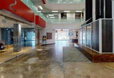 Spacious modern lobby with polished concrete floors and vibrant red wall accents.