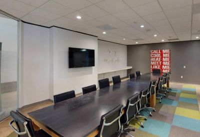 Large professional conference room featuring a long dark wood table and colorful checkered carpet.
