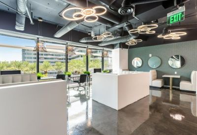 Modern coworking lounge with circular light fixtures and white counters.