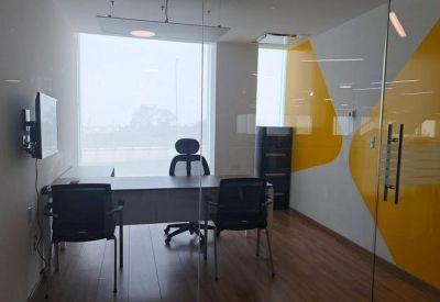 Private office suite with a wooden desk, executive chair, and yellow wall accents.
